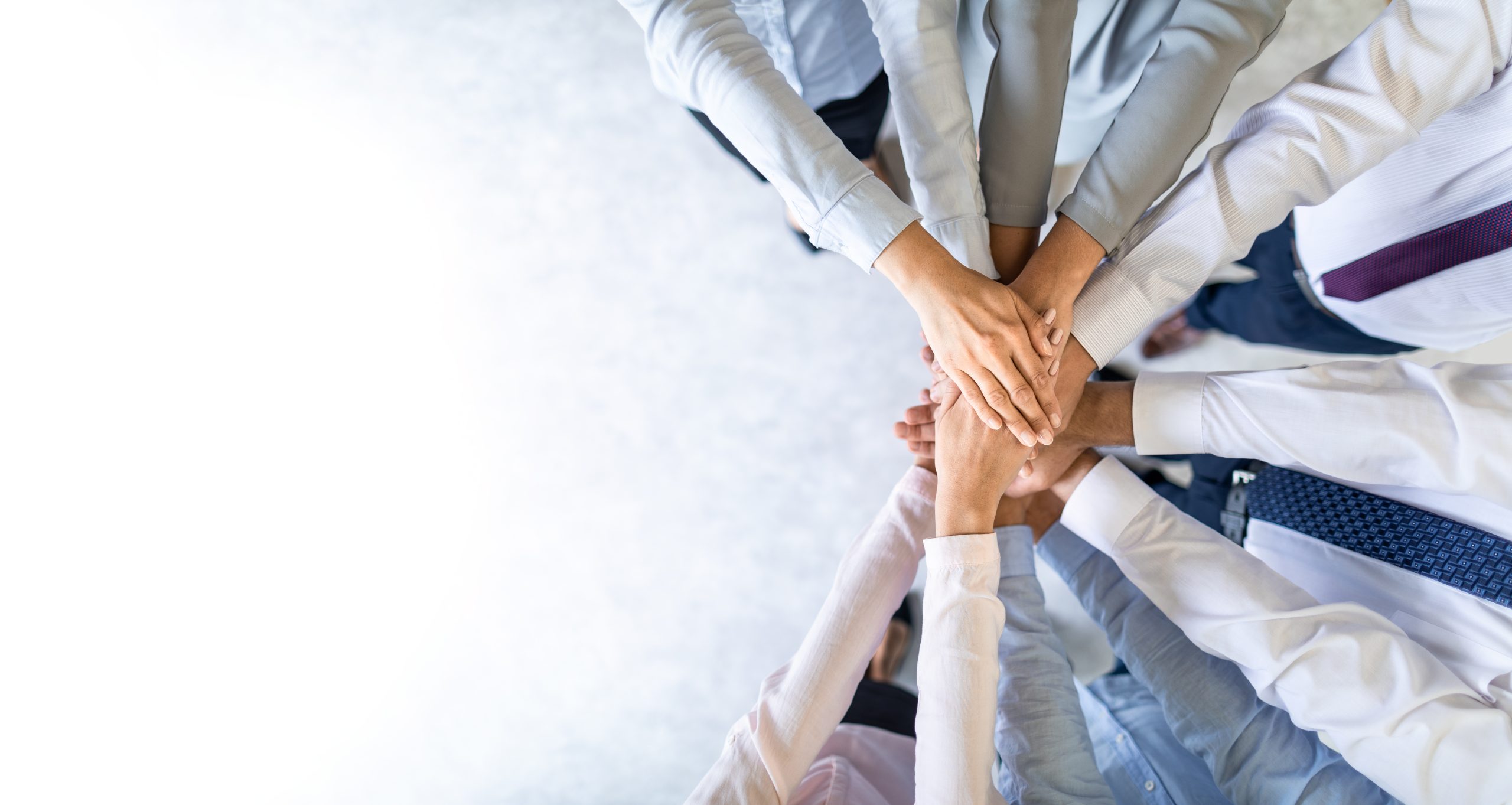 A group of employees putting their hands together to celebrate NetSuite success